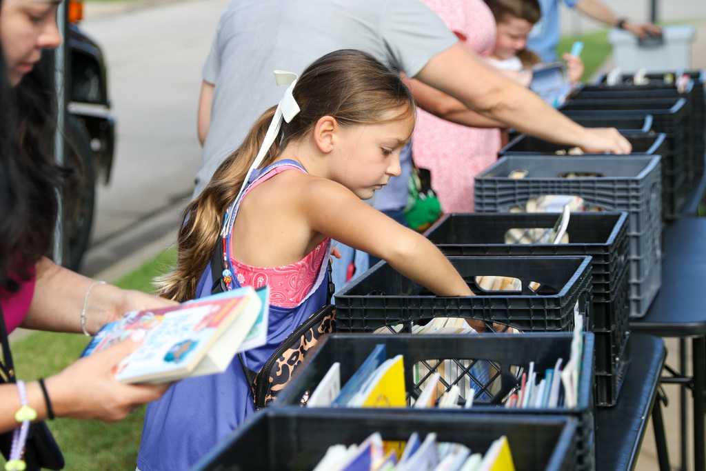girling sorting through books in a crate outside the bookmobile