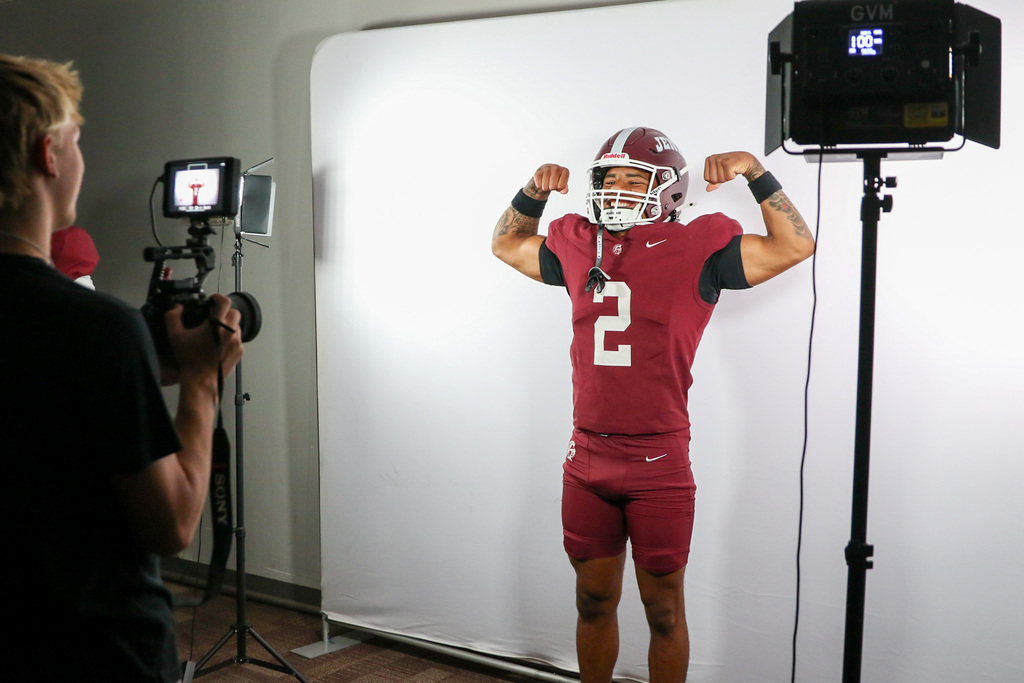 football player flexing for a video on a white background