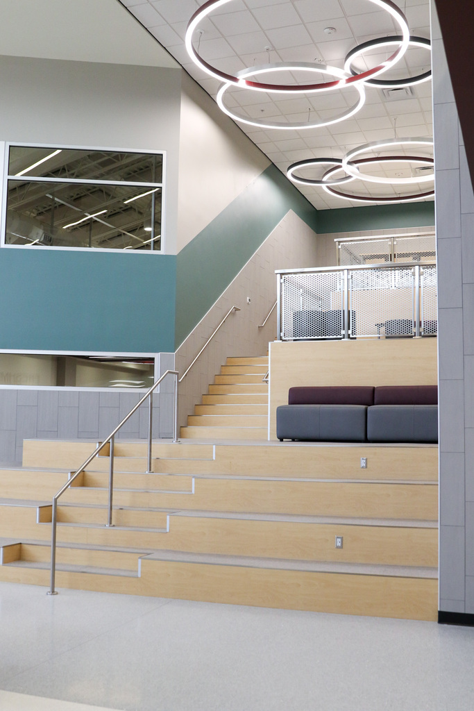 photo of the new seating area in the front commons area. includes stairs going up with built in seating and more closed off areas with couches