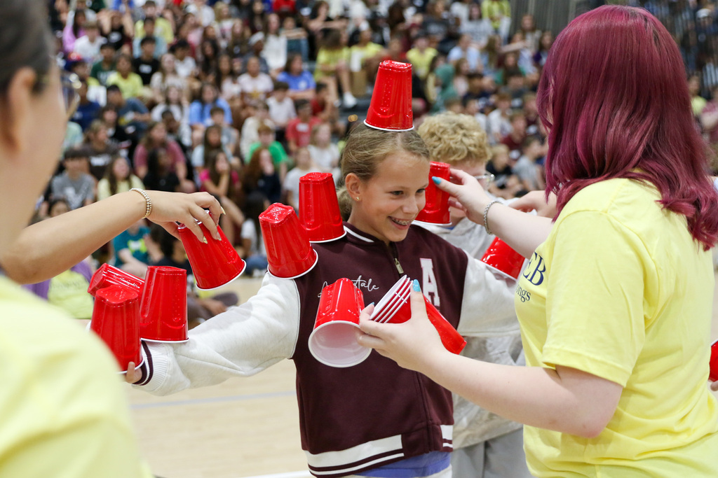 7th grader with red solo cups being stacked on her during a game