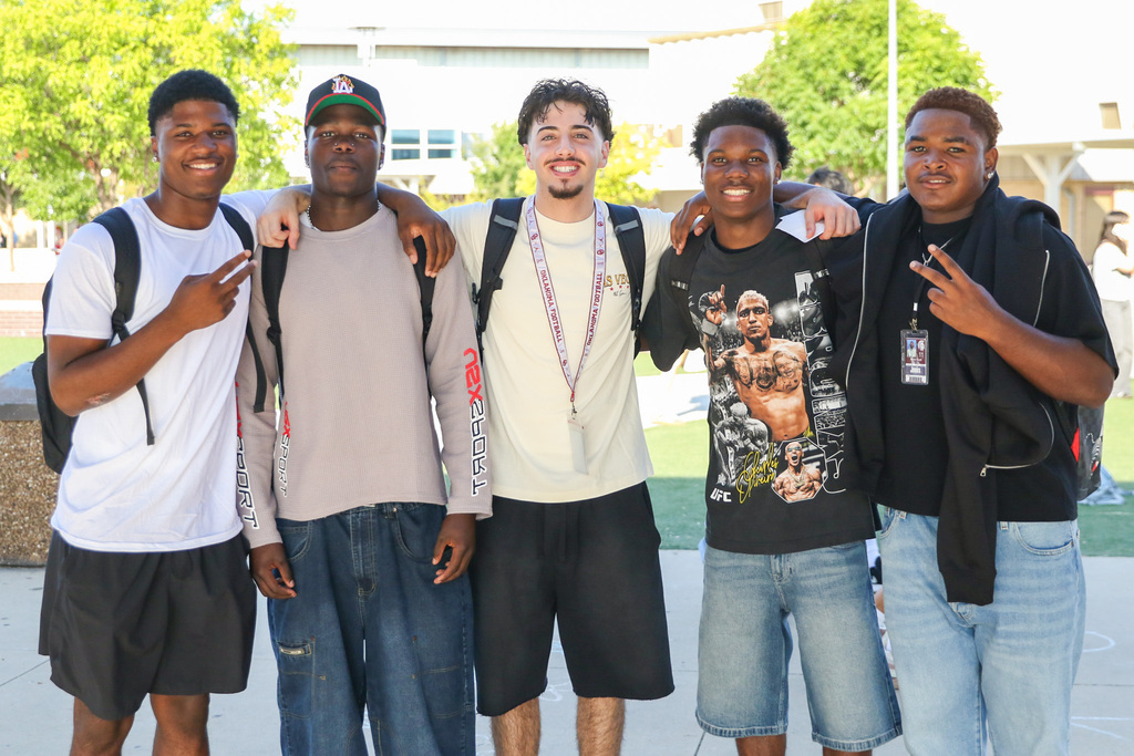 5 high school boys posing for a photo outside