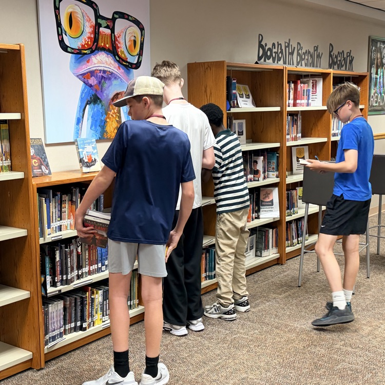 students looking at book shelf