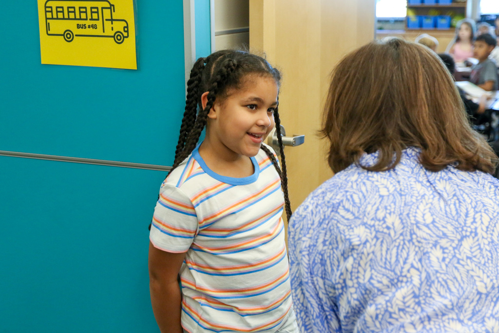 3rd grade girl being the classroom greeter and greeting dr. butterfield.