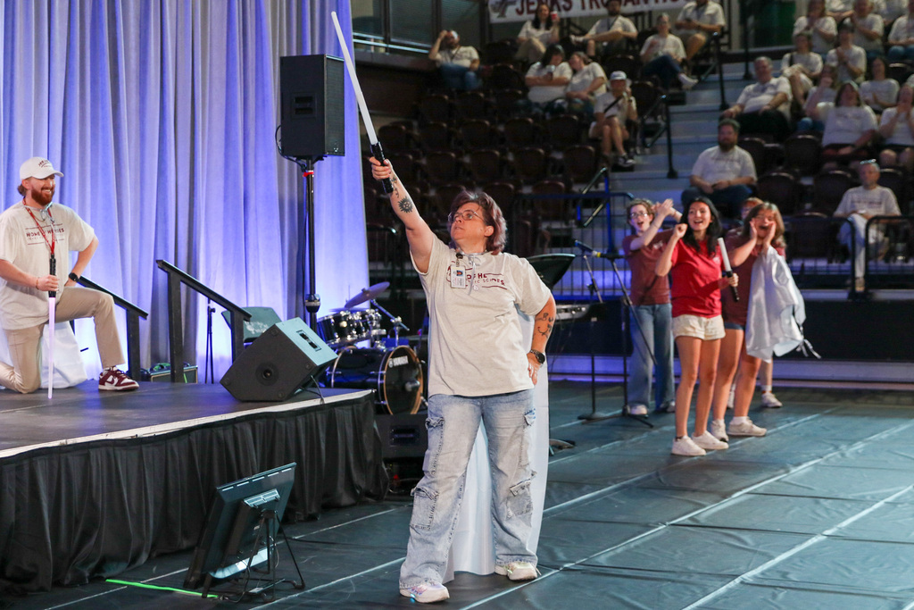 staff member who participated in dr butterifields entrnce doing a hero stance and pointing her light stick in the air