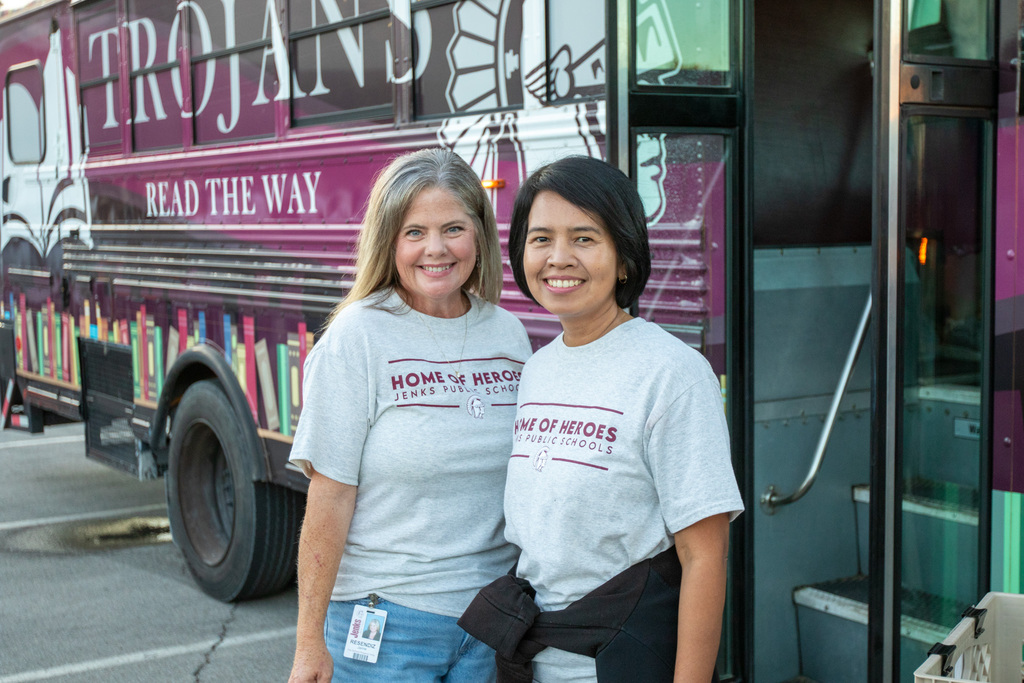 two staff members from fianace outside the bookmobile after taking a tour of it at the rally