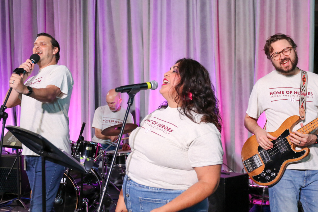 gold ball band singers, bass player, and drummer, all jamming out during their set