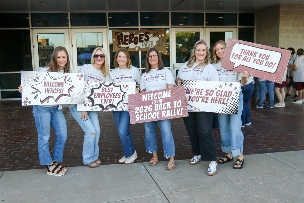 6 administrators from east and west intermediates holding signs welcoming staff to the rally