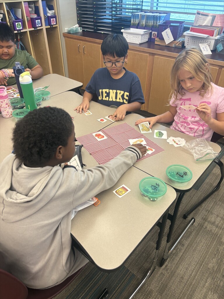 Group of 3 work together to solve a card puzzle.
