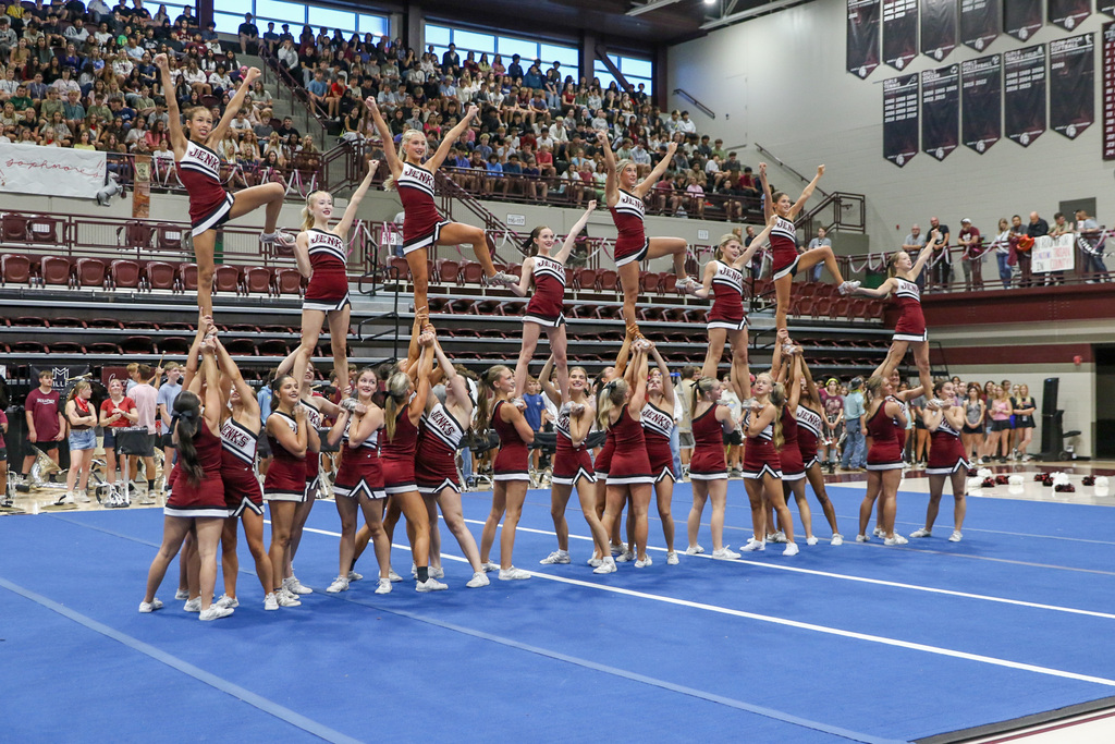 cheerleaders doing their team performace. they are in their final stunt pose.