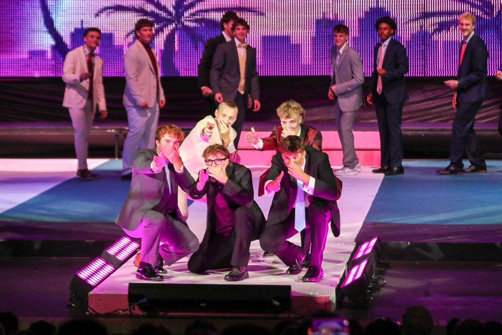 5 boys posing together at the end of the runway squatted down