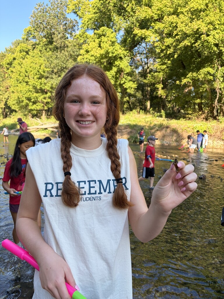 student holding a crawfish
