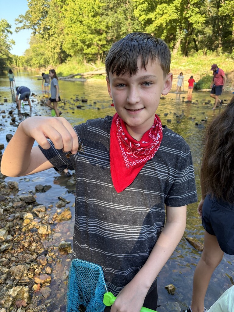 student holding a crawfish