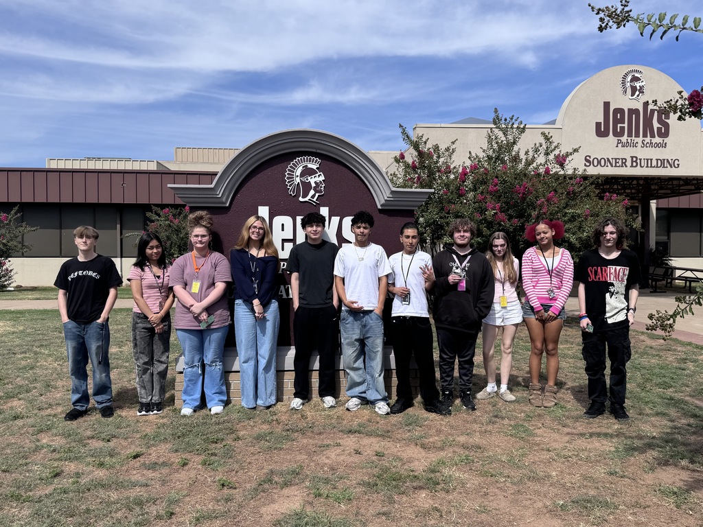 11 students standing in front of school