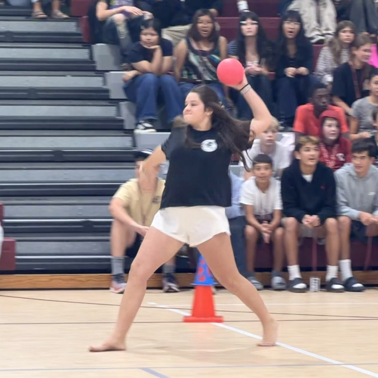 student throwing a pink dodgeball