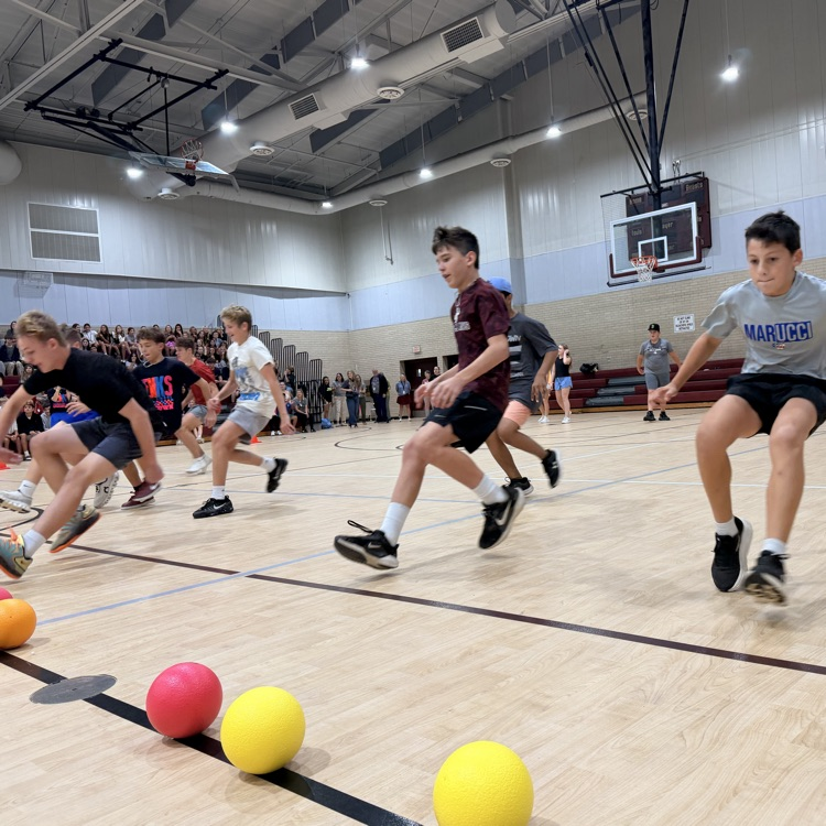 students running toward the center line to grab a dodgeball