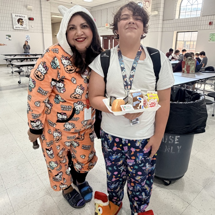 A vice principal and a student wearing pajamas at lunch