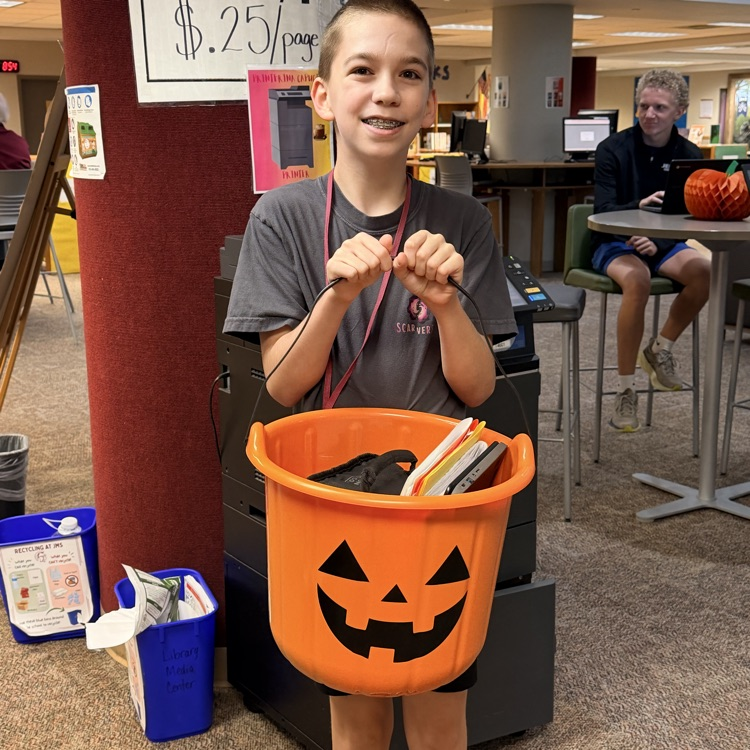 student holding his jack-o’-lantern pumpkin backpack