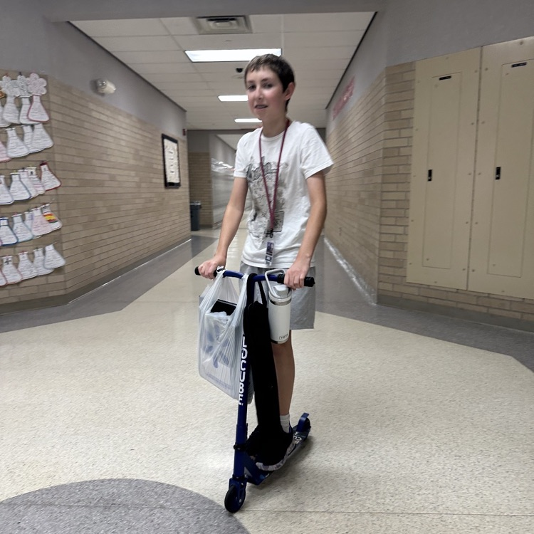 boy on scooter with a bag