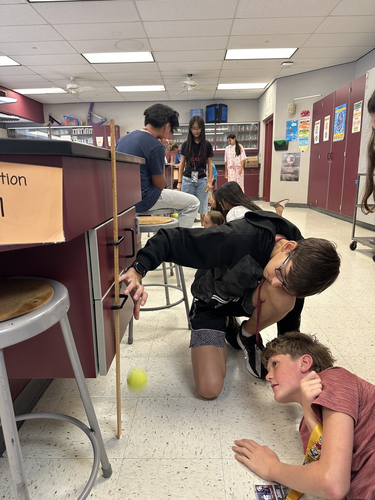 2 boys measuring how high a tennis ball bounces