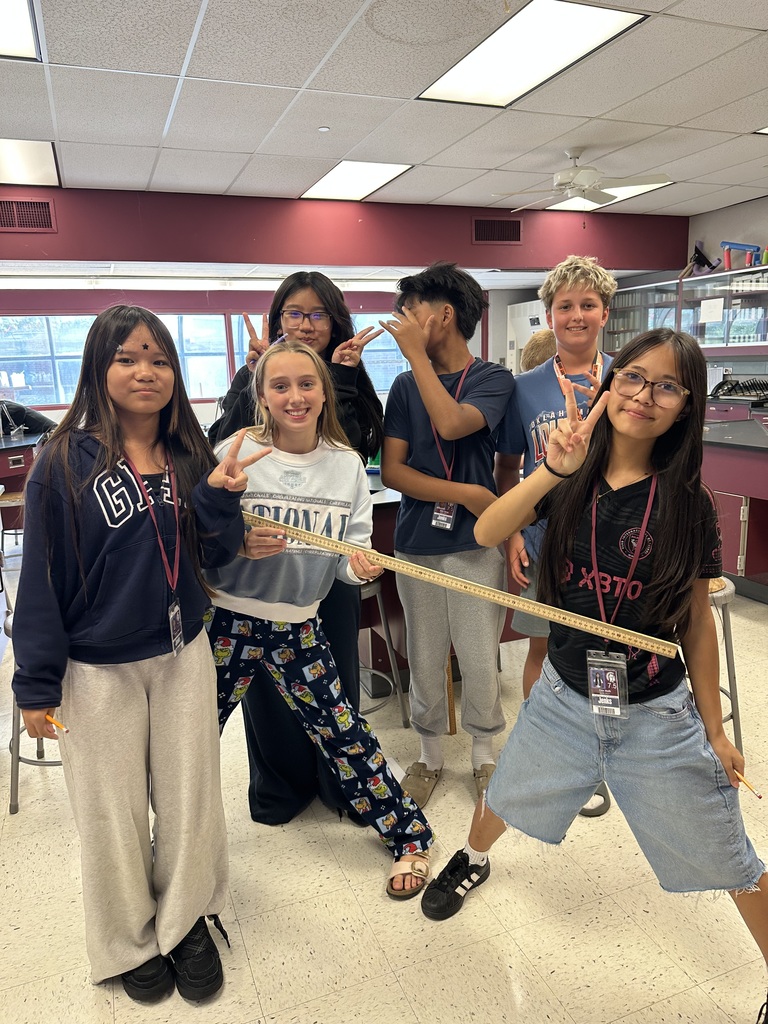 6 students holding a measuring stick