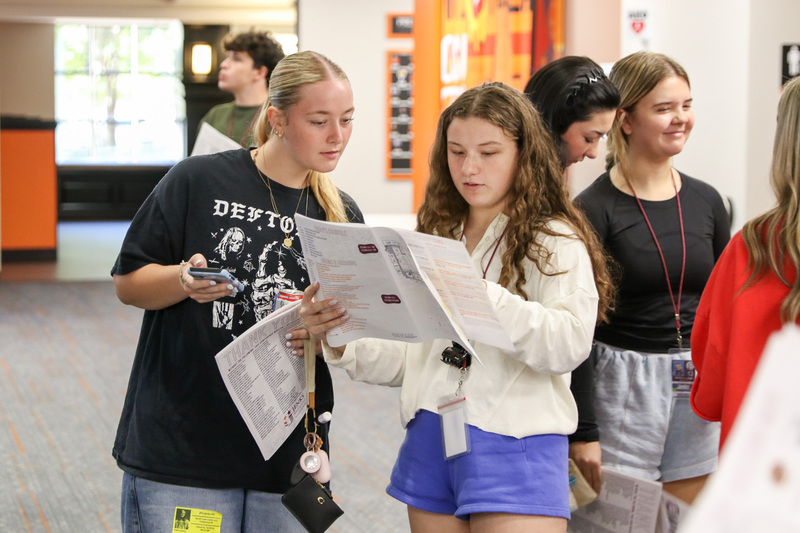 students looking at program booklet