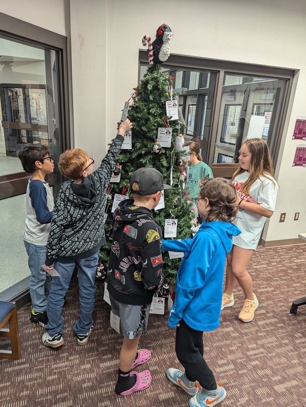 kids picking tags from project westly tree