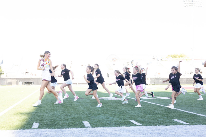 Young athletes chasing older Jenks athlete across football field 2026 fall