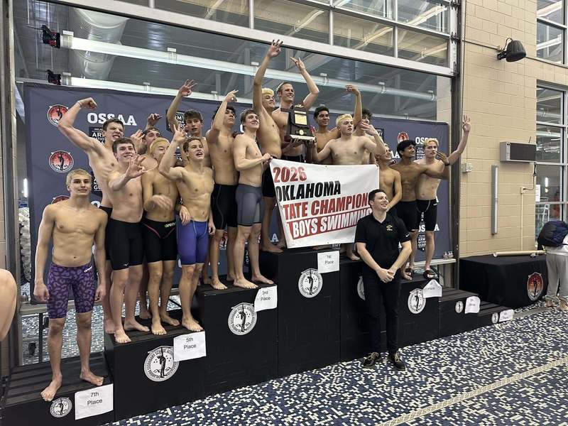 Jenks boys 2026 hold their state champion sign on the podium after winning  state