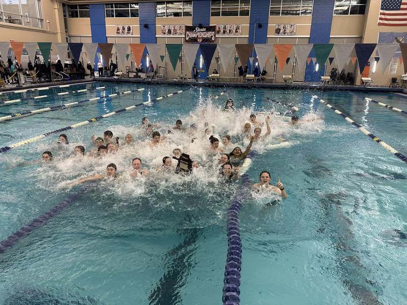 The swim team jumps into the pool after winning 2026 state