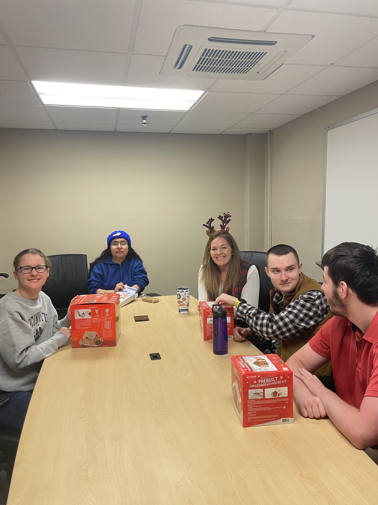 IMG_0257 (1) Four college age students in this photo with a teachers aid. They have gingerbread boxes. 