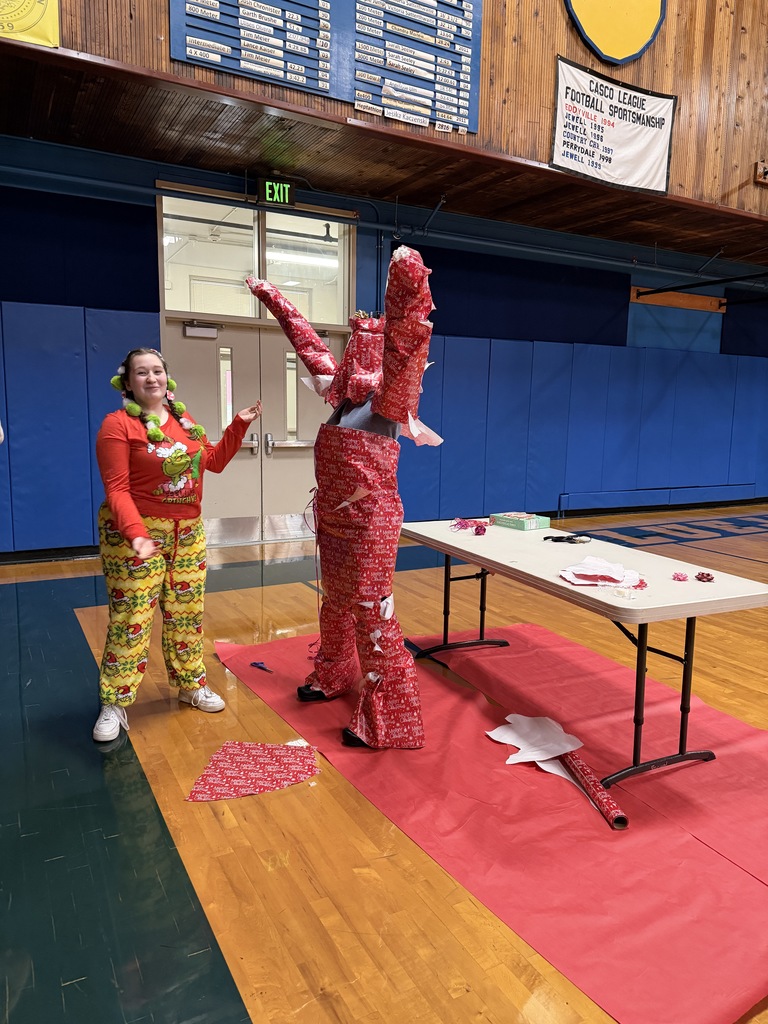 Teacher wrapped in red santa wrapping paper