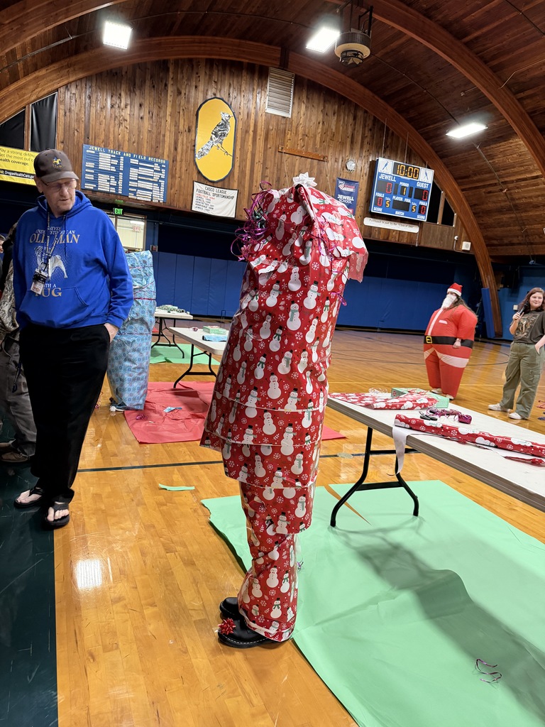 Teacher wrapped in red snowman wrapping paper