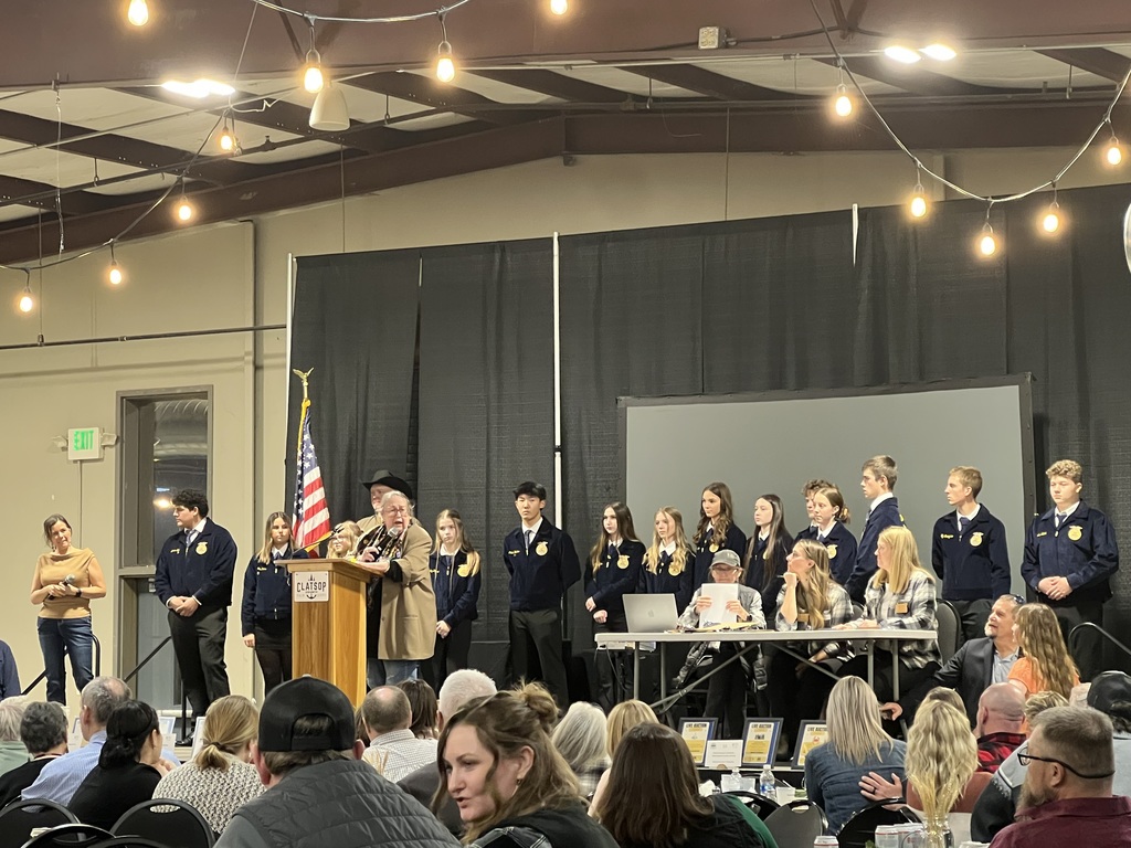 Stage full of people listening to a speech.