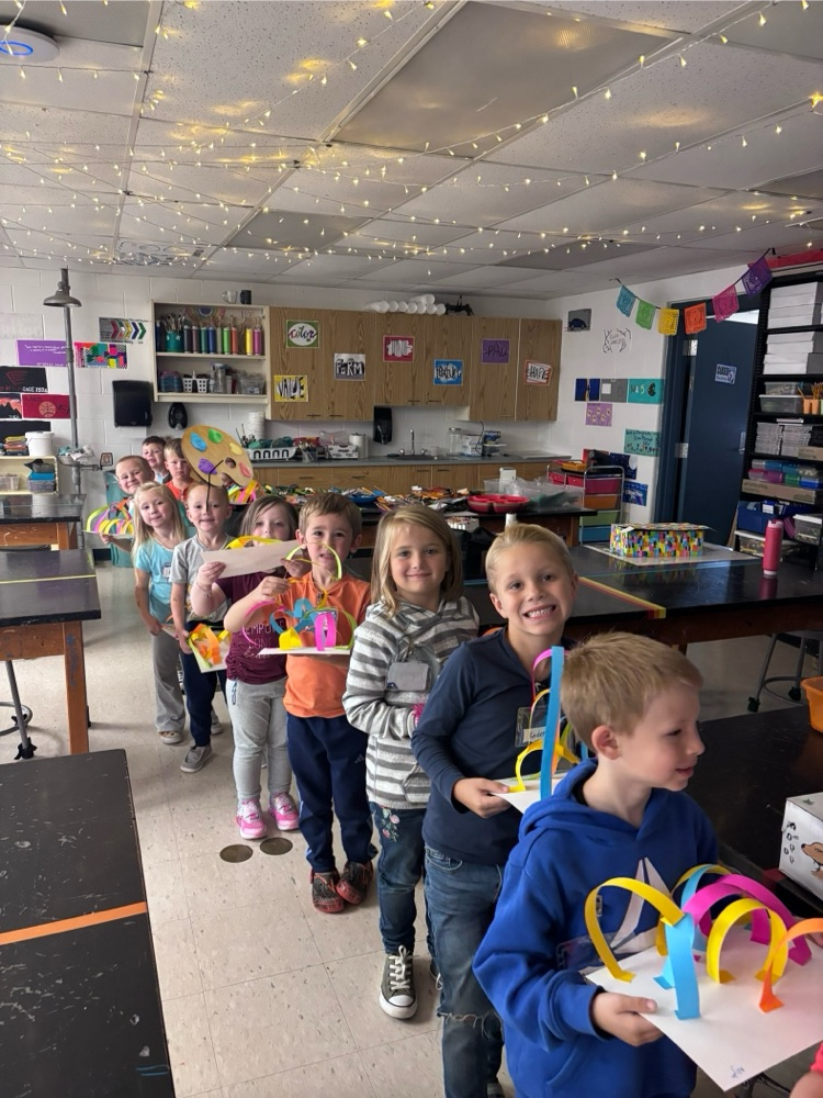 Kindergartners lined up with their paper sculptures