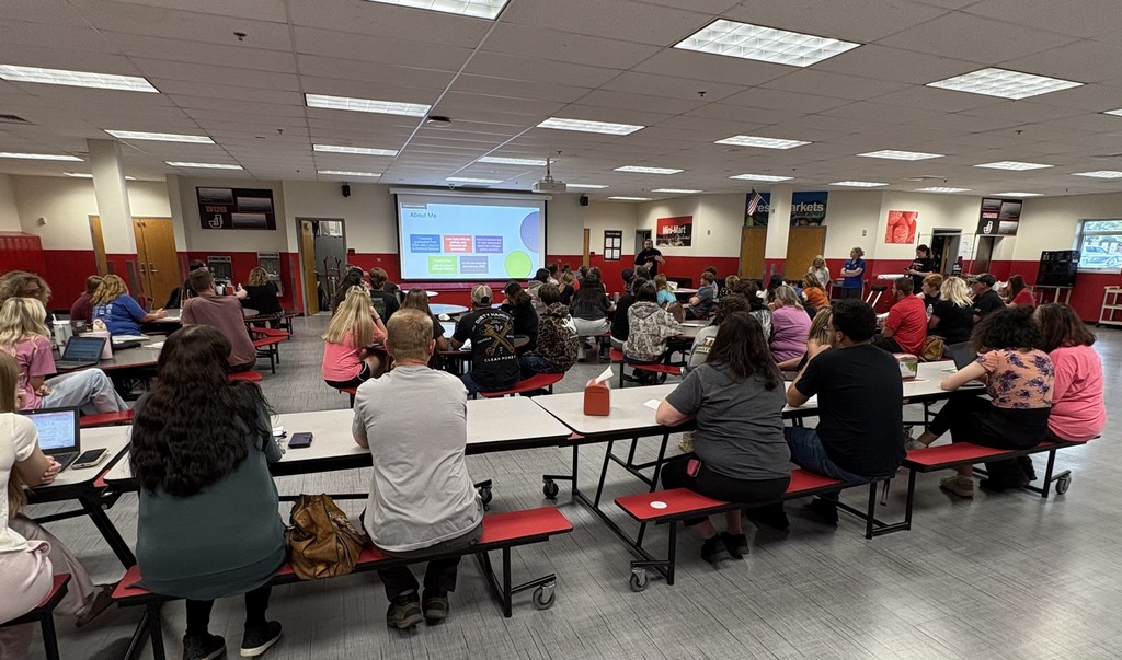 Parents and students sit in cafeteria listening to presentation for JCHS FAFSA Completion Night. 