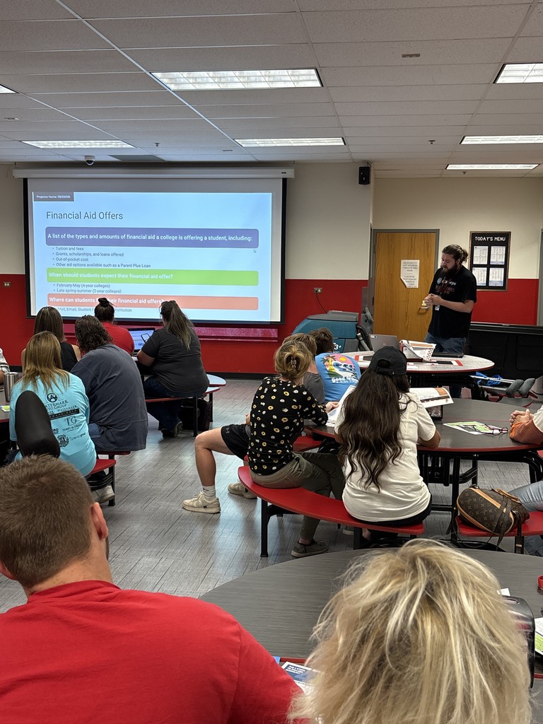 Parents and students sit in cafeteria listening to presentation for JCHS FAFSA Completion Night. 