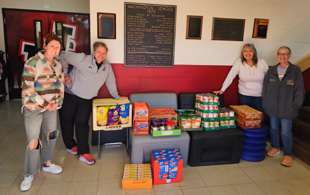 WMS staff standing around donation of non-perishable foods. 