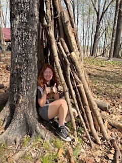 student demonstrating the sturdiness of her shelter