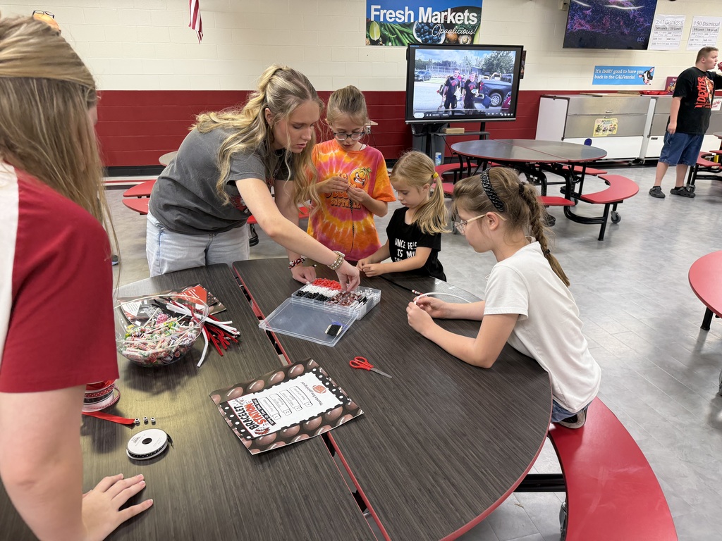 students and volunteers make bracelets during family night