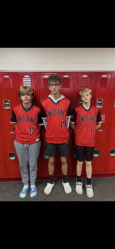 8th grade students stand in front of red lockers