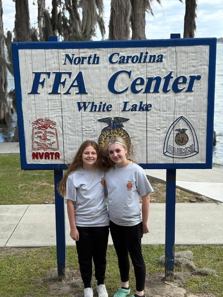 2 female ffa members in front of the nc ffa white lake center sign 