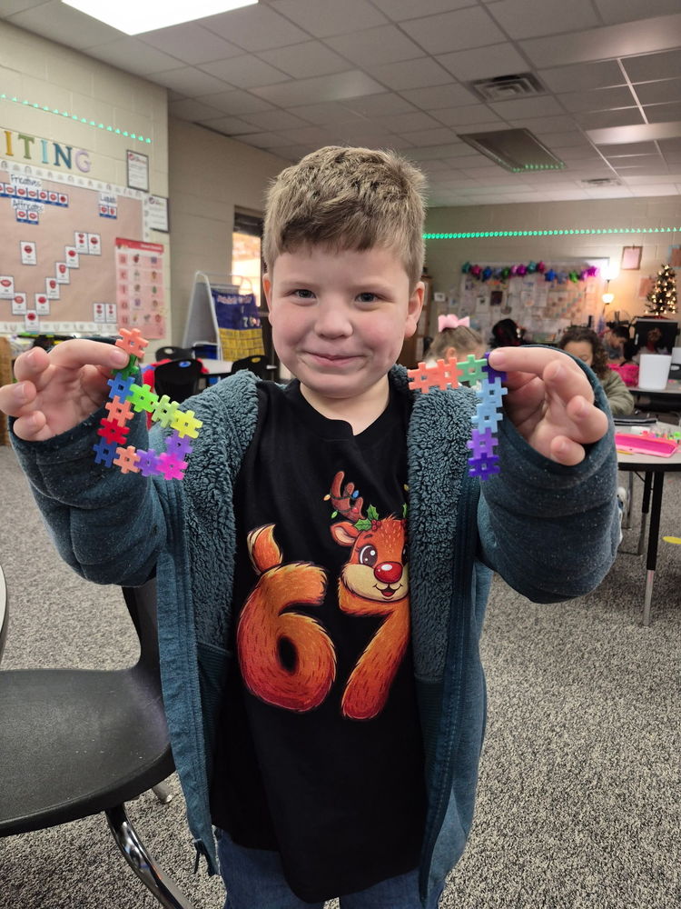 Student holding blocking showing number 6 and 7