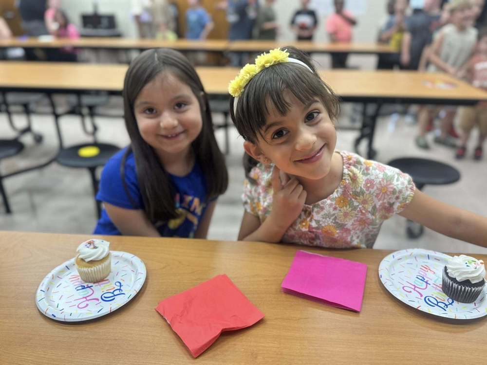 children eating cupcakes at a table