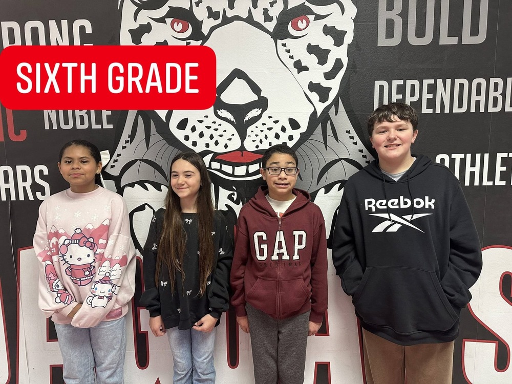 4 6th grade students standing in front of the jaguar mural 