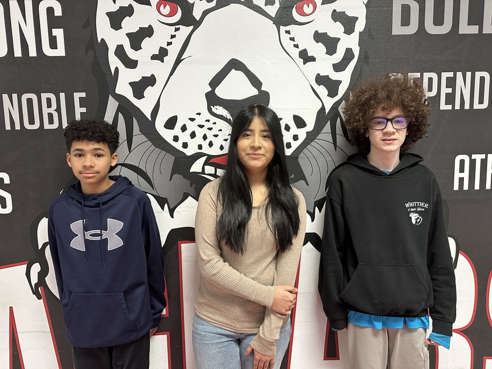 3 7th grade students in front of the jaguar mural 