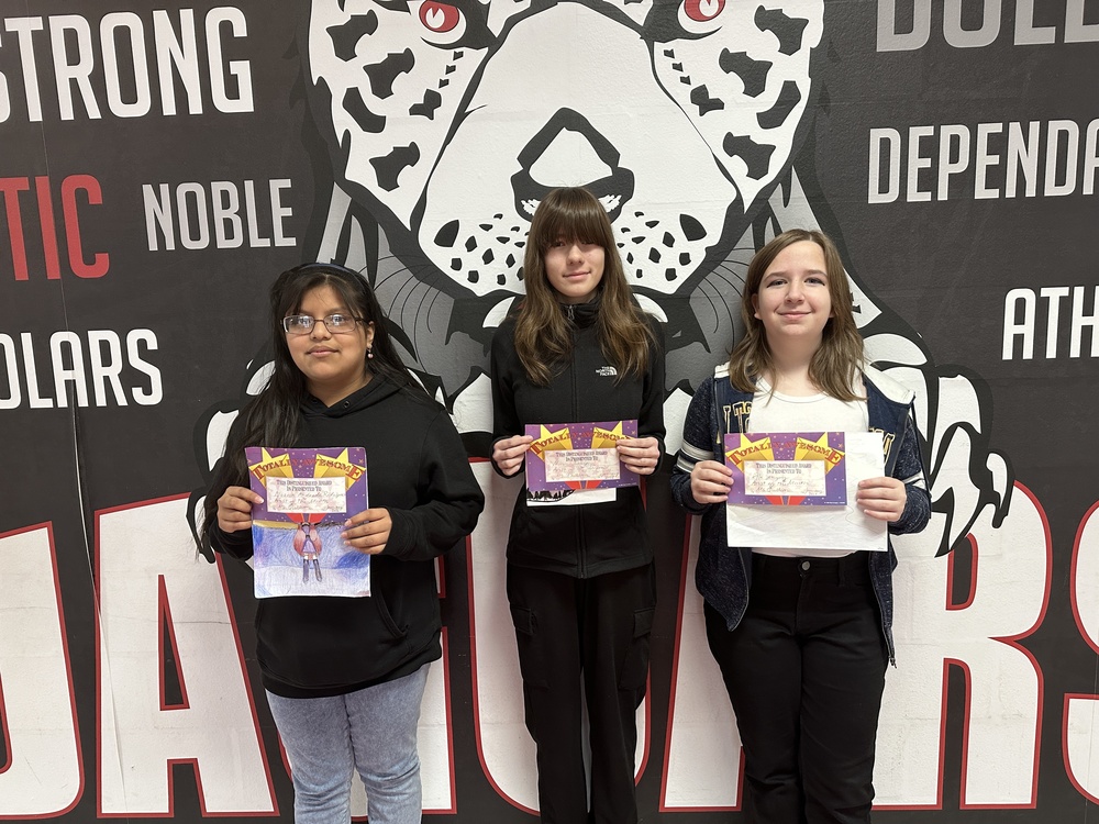 Picture of  3  female students holding up their artwork and certificates 