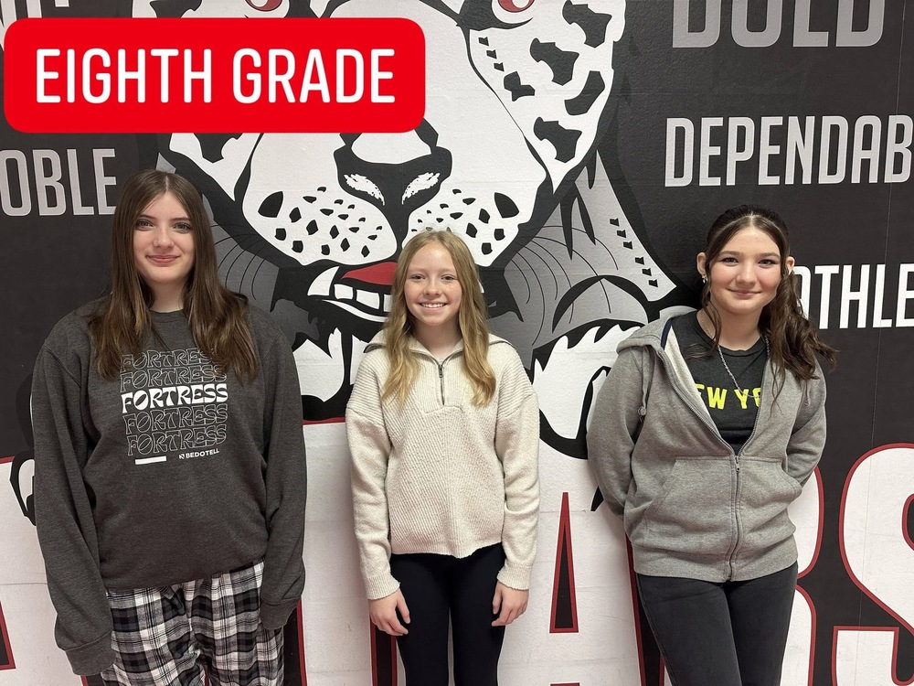 3  8th grade girls standing in front of the jaguar mural 