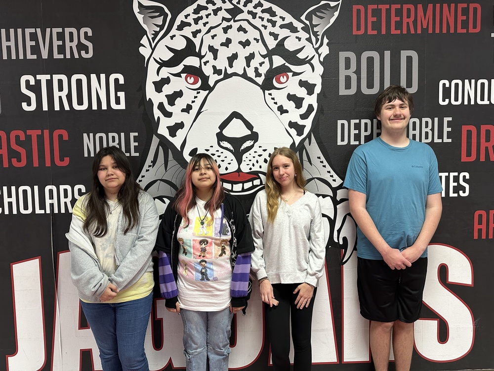 4 8th grade students standing in front of the jaguar mural 