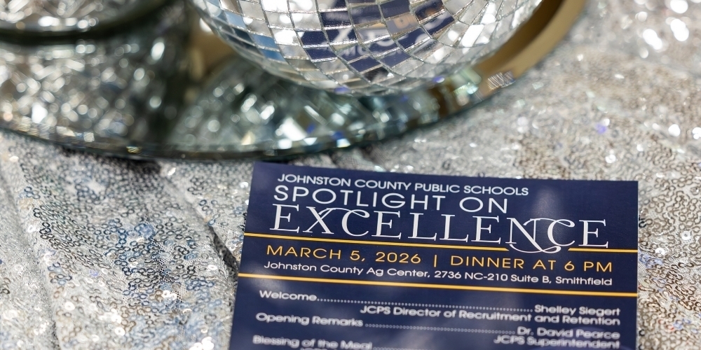 A Spotlight on Excellence program sits on a sequined table cloth.