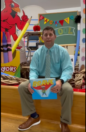 Principal Parrish holding the book "Brave"
